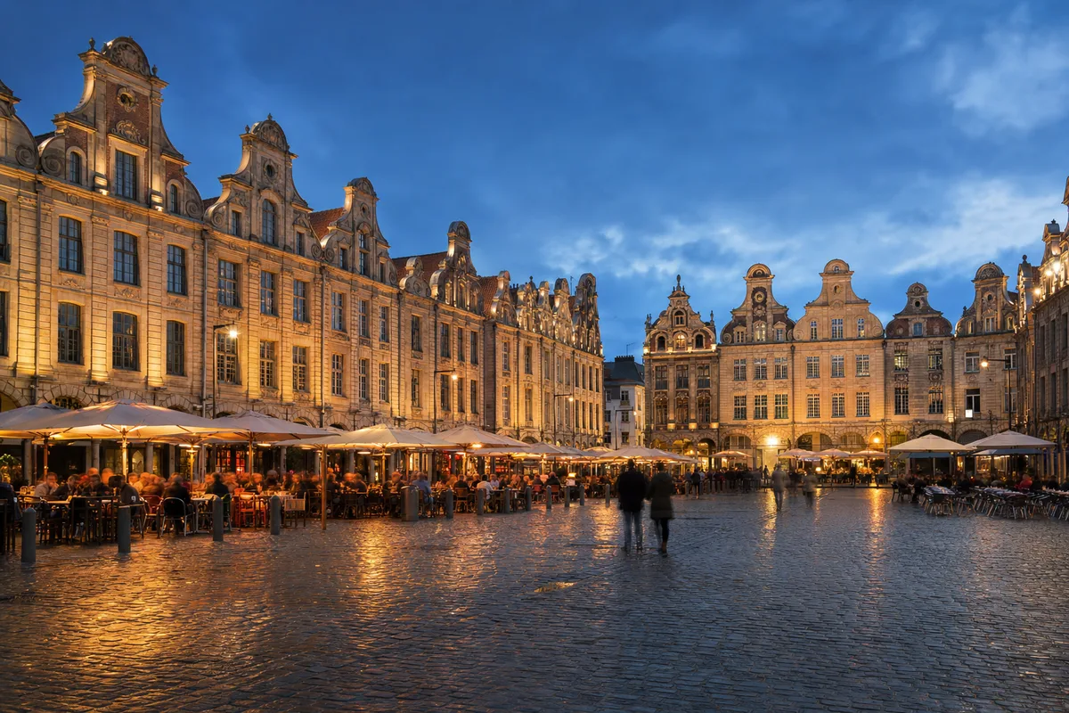 Place historique bordée de façades flamandes animée en soirée à Arras